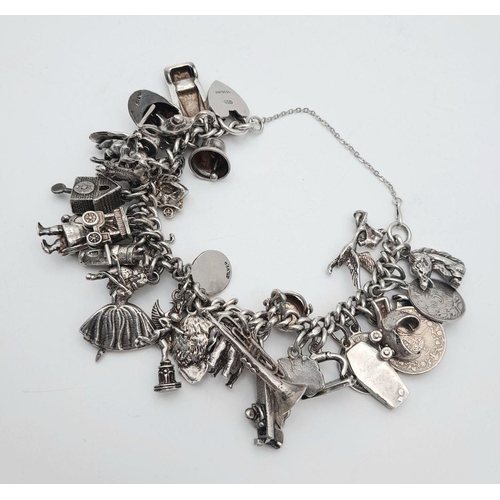 993 - A Substantial Sterling Silver Charm Bracelet. Over 30 charms, including: ballerina, vintage car, spe... 