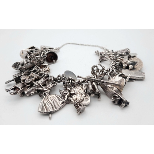 993 - A Substantial Sterling Silver Charm Bracelet. Over 30 charms, including: ballerina, vintage car, spe... 