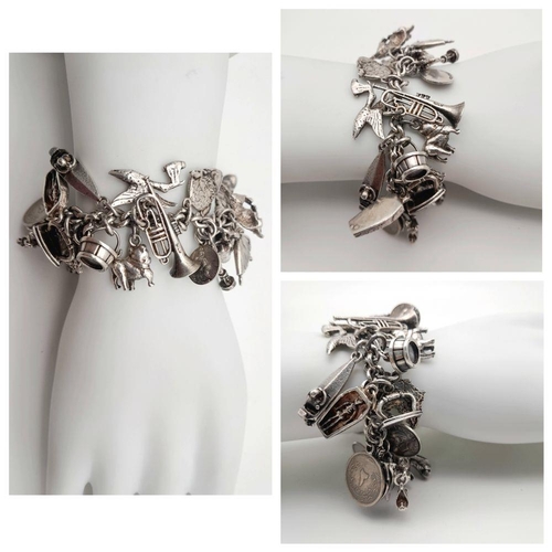 993 - A Substantial Sterling Silver Charm Bracelet. Over 30 charms, including: ballerina, vintage car, spe... 