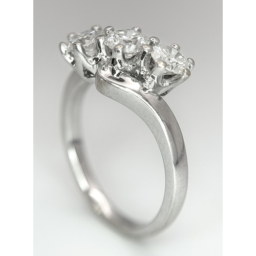 23 - AN 18K WHITE GOLD DIAMOND CROSSOVER TRILOGY RING. 1.20CT. 5G TOTAL WEIGHT. SIZE M. Ref: A/S 1195