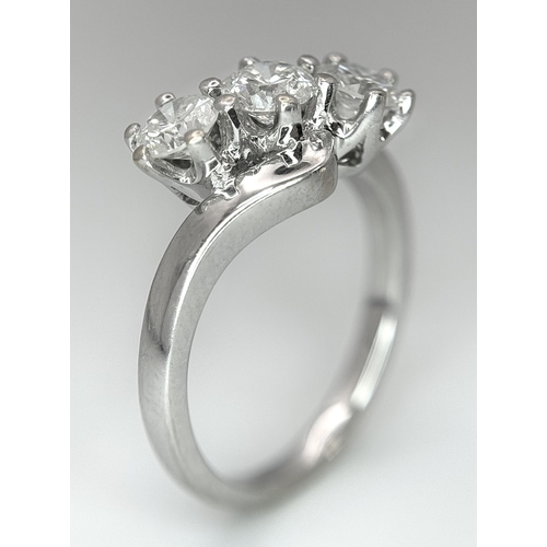 23 - AN 18K WHITE GOLD DIAMOND CROSSOVER TRILOGY RING. 1.20CT. 5G TOTAL WEIGHT. SIZE M. Ref: A/S 1195