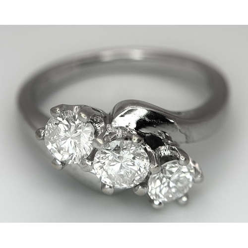 23 - AN 18K WHITE GOLD DIAMOND CROSSOVER TRILOGY RING. 1.20CT. 5G TOTAL WEIGHT. SIZE M. Ref: A/S 1195