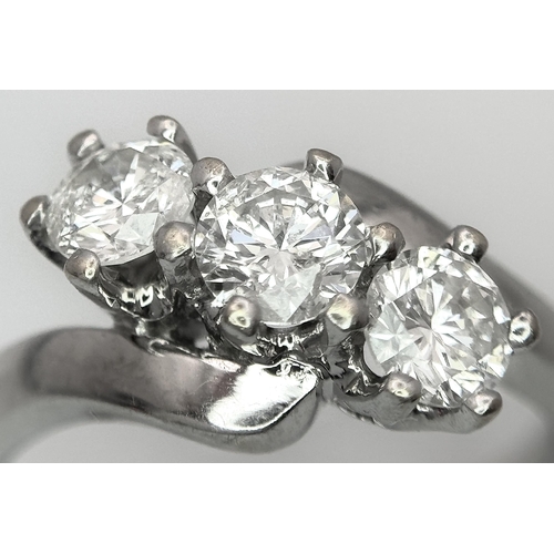 23 - AN 18K WHITE GOLD DIAMOND CROSSOVER TRILOGY RING. 1.20CT. 5G TOTAL WEIGHT. SIZE M. Ref: A/S 1195