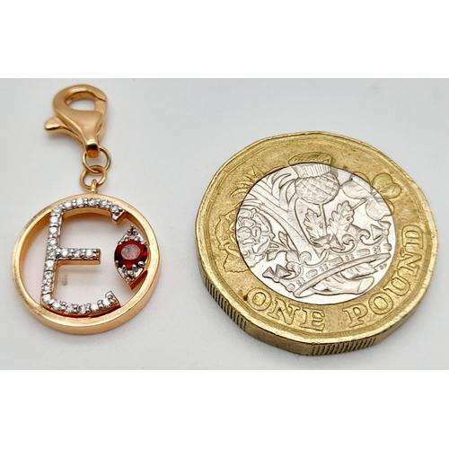 492 - A 14K ROSE GOLD DIAMOND & RUBY SET INITIAL E CHARM. 2.1G TOTAL WEIGHT. APPROX. 2.9CM IN LENGTH AND 1... 