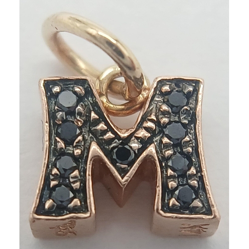 625 - A 14K ROSE GOLD BLACK DIAMOND SET INITIAL M CHARM / PENDANT. 1.2G TOTAL WEIGHT. APPROX 0.8CM IN HEIG... 