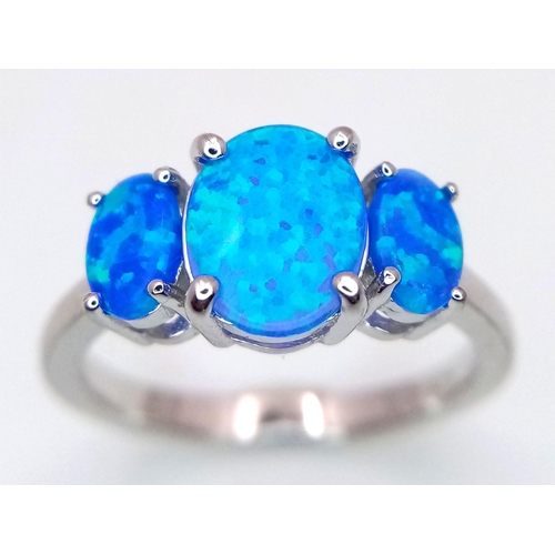 286 - An eye catching, sterling silver ring with three mesmerising, synthetic opal oval cabochons with pre... 