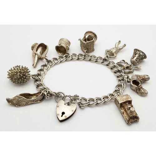 1085 - A vintage Solid Silver 925 Charm Bracelet, with 9 charms, 50.4 grams, 18.5cm, Heart padlock and safe... 