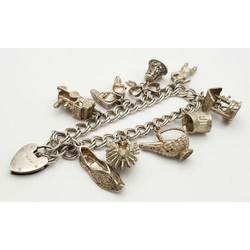 1085 - A vintage Solid Silver 925 Charm Bracelet, with 9 charms, 50.4 grams, 18.5cm, Heart padlock and safe... 