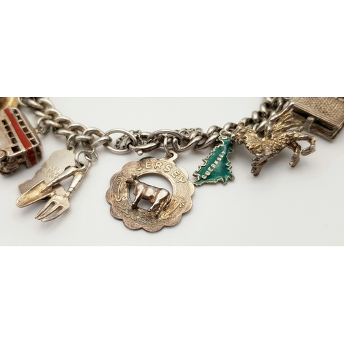 145 - A Vintage Solid Silver 925 Charm Bracelet, with 19 charms, 86 grams, 18.5cm. In good condition.