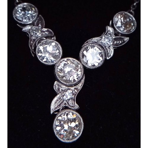 708 - An Art Deco Platinum and Diamond Lavaliere Necklace. 3.2ctw of old European round cut diamonds with ... 