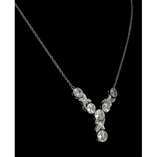 708 - An Art Deco Platinum and Diamond Lavaliere Necklace. 3.2ctw of old European round cut diamonds with ... 