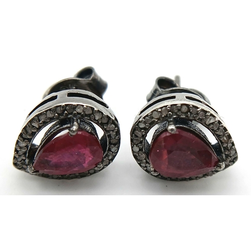 924 - A pair of 925 silver stud earrings featuring pear-cut ruby gemstones surrounded by a halo of sparkli... 