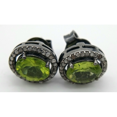 917 - A pair of peridot gemstone stud earrings, featuring central oval-cut peridot gemstones, surrounded b... 