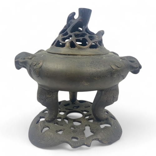 932 - An antique Chinese Bronze Tripod Censer with Pierced Lid. Engraved floral patterns, supported by thr... 