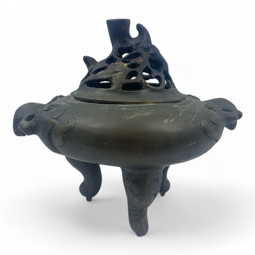 932 - An antique Chinese Bronze Tripod Censer with Pierced Lid. Engraved floral patterns, supported by thr... 