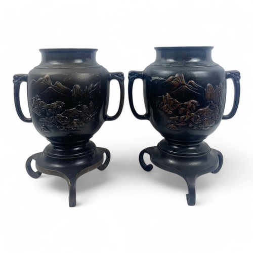 953 - A Pair of Antique Japanese Bronze Urns.
Intricate engraved landscape motifs and tripod bases. Includ... 