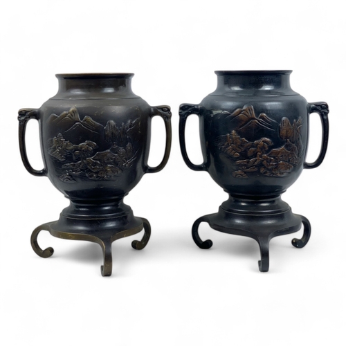 953 - A Pair of Antique Japanese Bronze Urns.
Intricate engraved landscape motifs and tripod bases. Includ... 