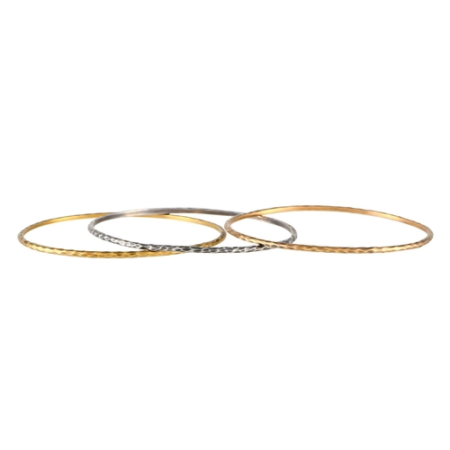 496 - A Tiffany & Co. 18K Yellow Gold, White Gold, Rose Gold Tricolor Bangle Set.This set of tricolor brac... 