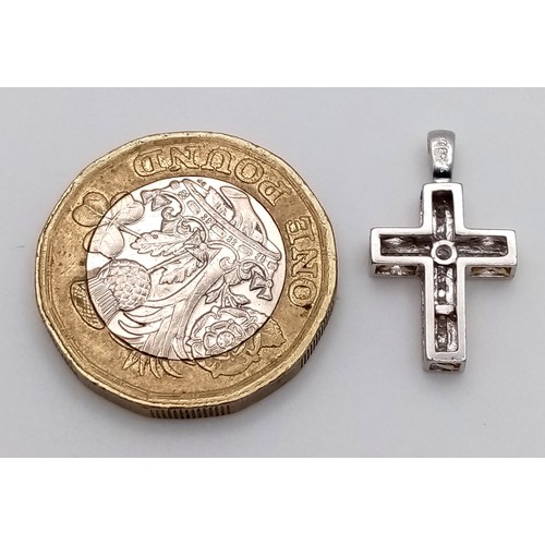 394 - AN 18K WHITE GOLD DIAMOND SET CROSS 1.55G TOTAL WEIGHT. APPROX. 1.1CM IN WIDTH AND 2CM IN LENGTH. Re... 