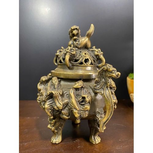 1306 - An antique Chinese Bronze Tripod Censer with Lid. Detailed hand carved figures of dragons, and foo d... 