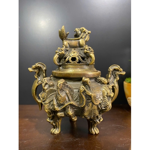 1306 - An antique Chinese Bronze Tripod Censer with Lid. Detailed hand carved figures of dragons, and foo d... 