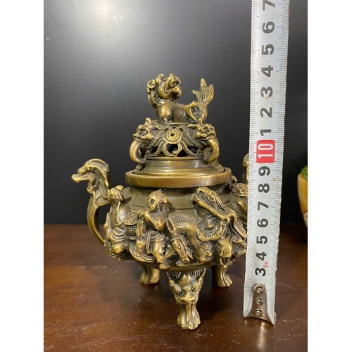 1306 - An antique Chinese Bronze Tripod Censer with Lid. Detailed hand carved figures of dragons, and foo d... 