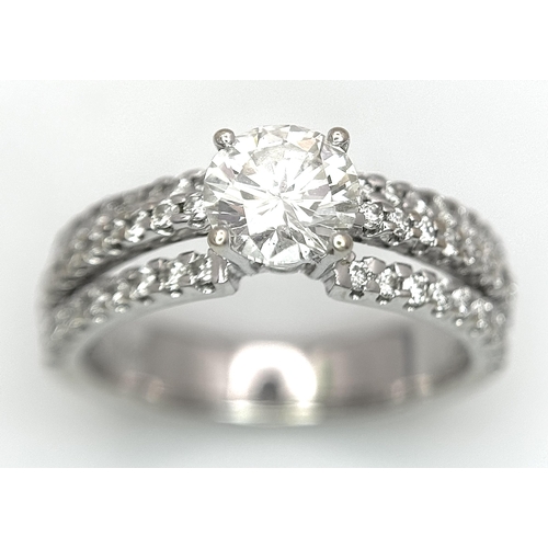 34 - A Stunning 18K white Gold and Diamond Ring. Brilliant round cut 0.70ctw centre diamond (SI1) with th... 