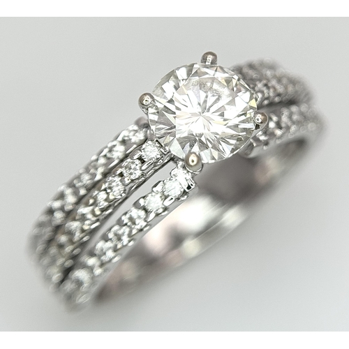 34 - A Stunning 18K white Gold and Diamond Ring. Brilliant round cut 0.70ctw centre diamond (SI1) with th... 