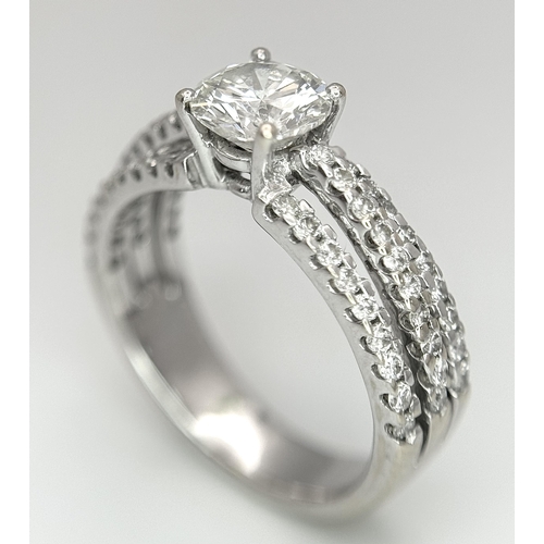 34 - A Stunning 18K white Gold and Diamond Ring. Brilliant round cut 0.70ctw centre diamond (SI1) with th... 