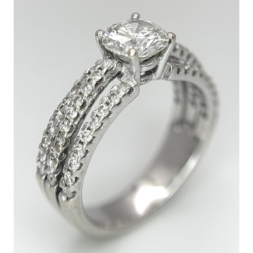 34 - A Stunning 18K white Gold and Diamond Ring. Brilliant round cut 0.70ctw centre diamond (SI1) with th... 