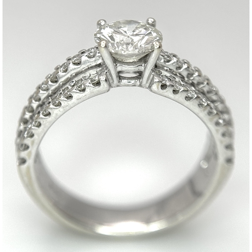 34 - A Stunning 18K white Gold and Diamond Ring. Brilliant round cut 0.70ctw centre diamond (SI1) with th... 