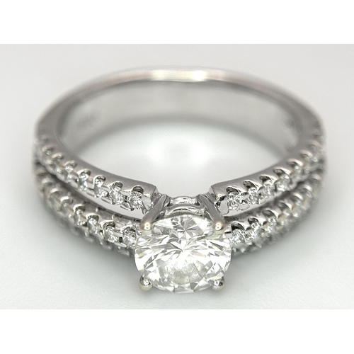 34 - A Stunning 18K white Gold and Diamond Ring. Brilliant round cut 0.70ctw centre diamond (SI1) with th... 