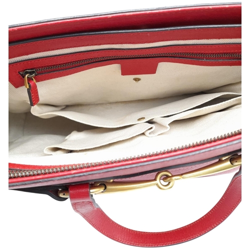 545 - A Gucci Red Leather Horsebit Top Handle Bag. Red leather exterior with gold-toned hardware and dual ... 