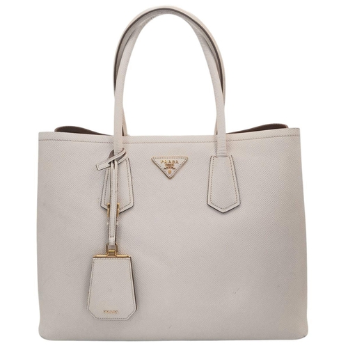 713 - A Prada Saffiano Leather Double Bag. White leather exterior with gold-tone hardware and top handles.... 