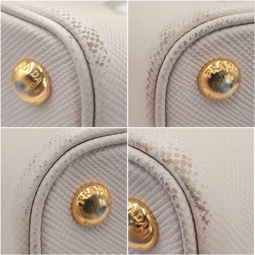 713 - A Prada Saffiano Leather Double Bag. White leather exterior with gold-tone hardware and top handles.... 