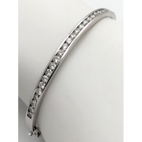 321 - An 18K White Gold Diamond Bangle. 21 Brilliant round cut diamonds in a channel formation - 2.10ctw. ... 