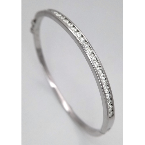 321 - An 18K White Gold Diamond Bangle. 21 Brilliant round cut diamonds in a channel formation - 2.10ctw. ... 