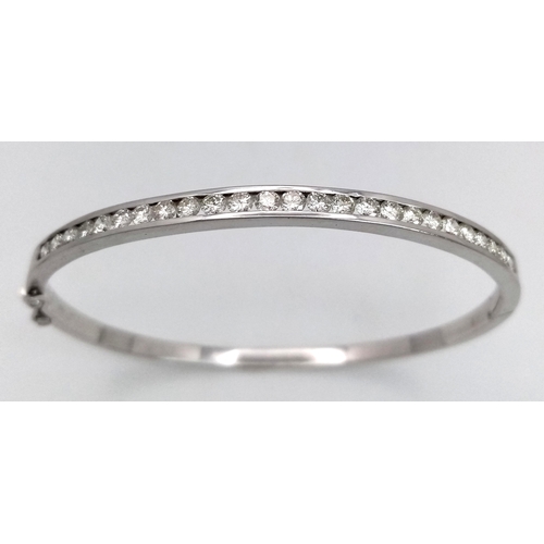 321 - An 18K White Gold Diamond Bangle. 21 Brilliant round cut diamonds in a channel formation - 2.10ctw. ... 