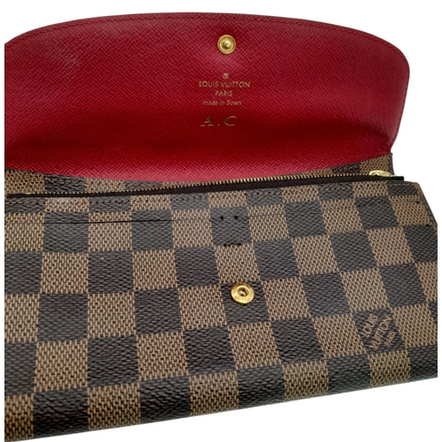 657 - A Louis Vuitton Damier Ebene Emilie Wallet. Crafted from signature Damier Ebene checkered canvas in ... 