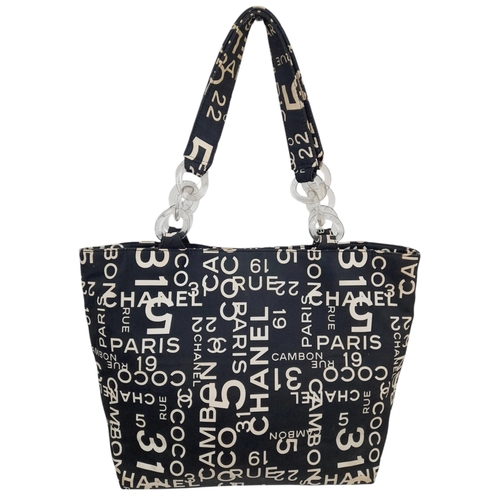 215 - A Chanel Black and Beige Rue Cambon Tote/Beach Bag. Textile exterior with silver-toned and clear res... 