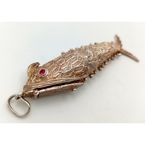 380 - A Vintage Articulated 925 Silver Fish Pendant. Hidden compartment under gill. Ruby eyes. 8cm. 17g