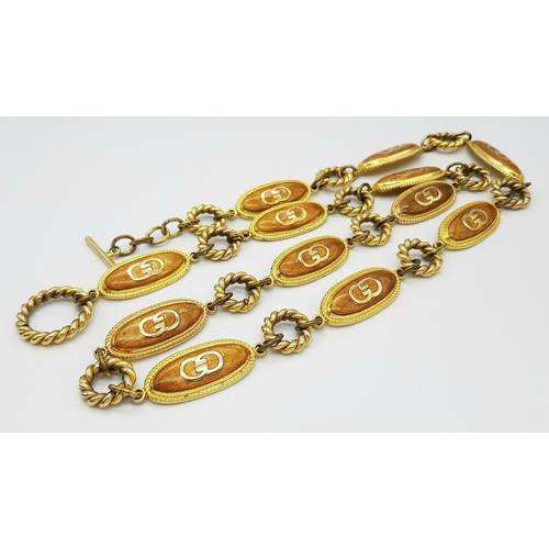 41 - A Vintage Gucci Gilded Metal Belt. Oval monogram design. 90cm length. Ref: 20878