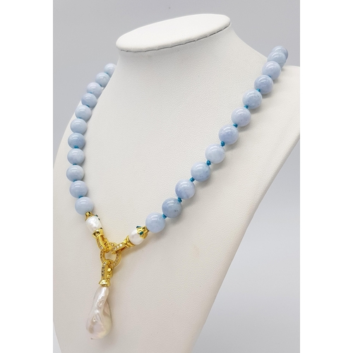 450 - An Aquamarine Necklace with Hanging Baroque Pendant. 10mm beads. 6cm pendant. Gilded clasp with pear... 