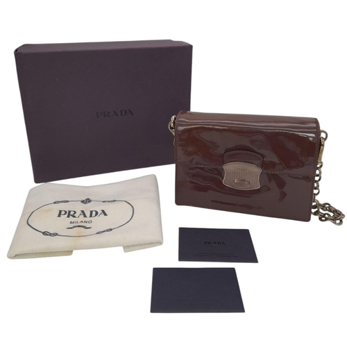 490 - A Prada Vernice Sound Bag. Glossy brown leather exterior, silver-tone hardware, features a detachabl... 