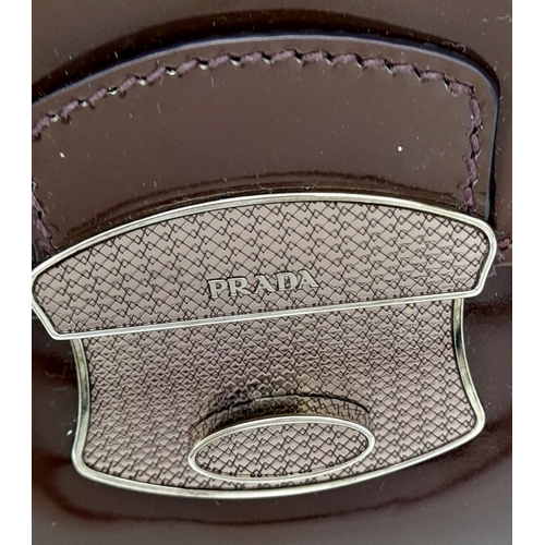 490 - A Prada Vernice Sound Bag. Glossy brown leather exterior, silver-tone hardware, features a detachabl... 