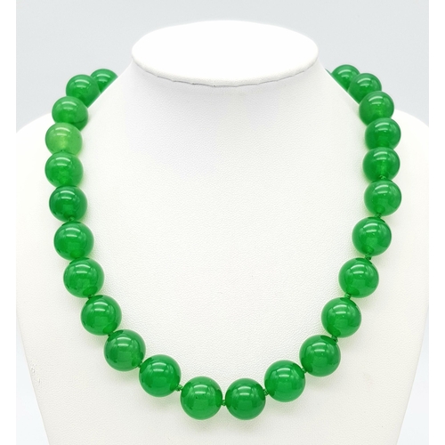 498 - A Vivid Green Jade Large Bead Necklace. 14mm beads. 42cm necklace length.