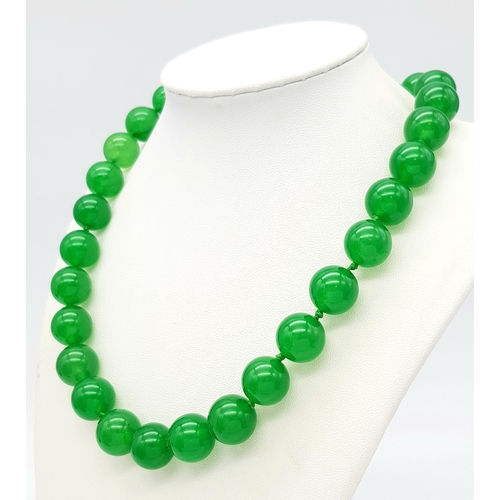 498 - A Vivid Green Jade Large Bead Necklace. 14mm beads. 42cm necklace length.