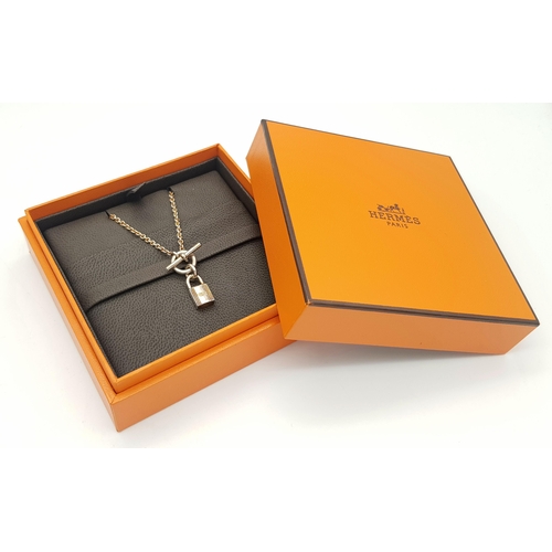 552 - An Hermes 'Kelly' Gilded 925 Silver Padlock Pendant on Gilded Silver Chain. 2cm and 40cm. 11.4g. Com... 