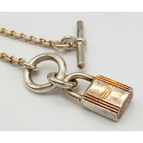 552 - An Hermes 'Kelly' Gilded 925 Silver Padlock Pendant on Gilded Silver Chain. 2cm and 40cm. 11.4g. Com... 