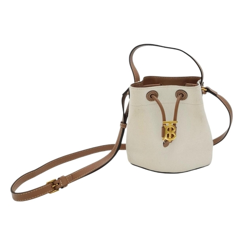 608 - A Burberry Ivory TB Mini Bucket Bag. Canvas exterior with gold-toned hardware, leather trim, adjusta... 